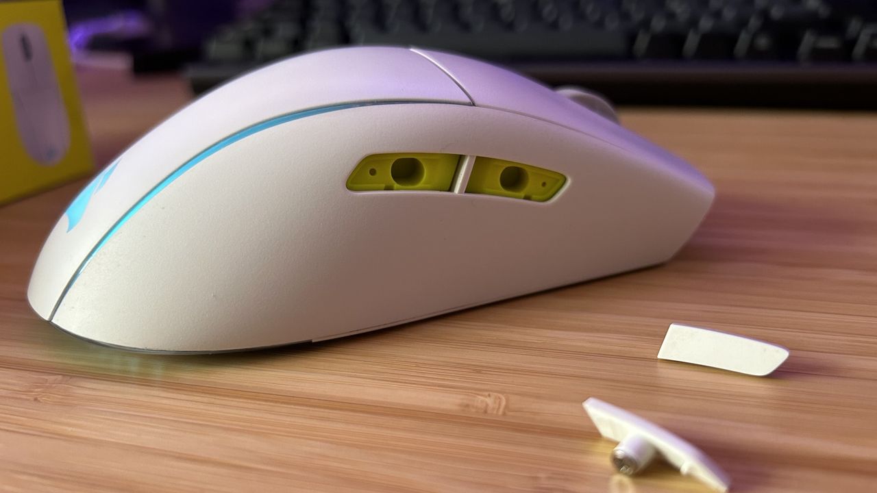 Corsair M75 Wireless with side buttons removed and placed to the side on a wooden table