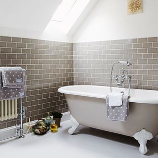 bathroom with pale grey metro tiles and white flooring