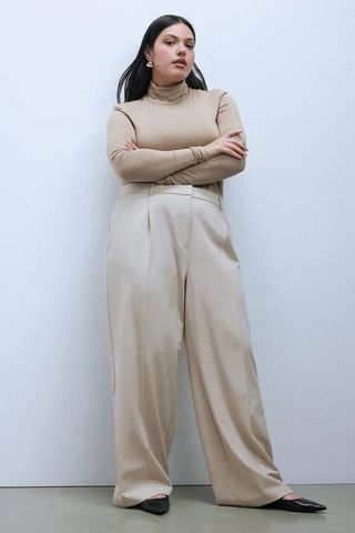 H&M model in beige shirt and beige pants