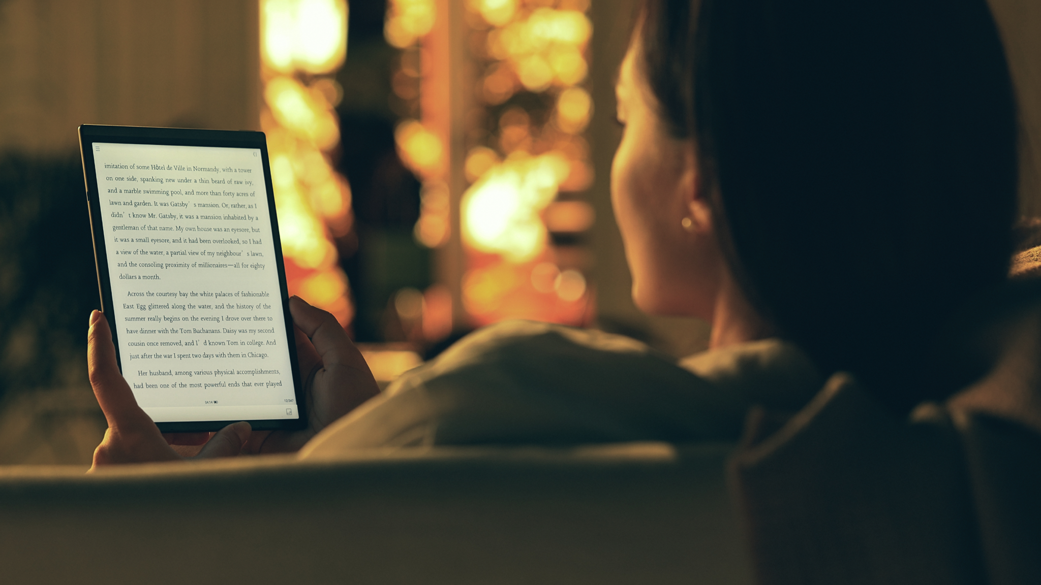 A woman on a sofa reading on the AINOTE Air 2 tablet