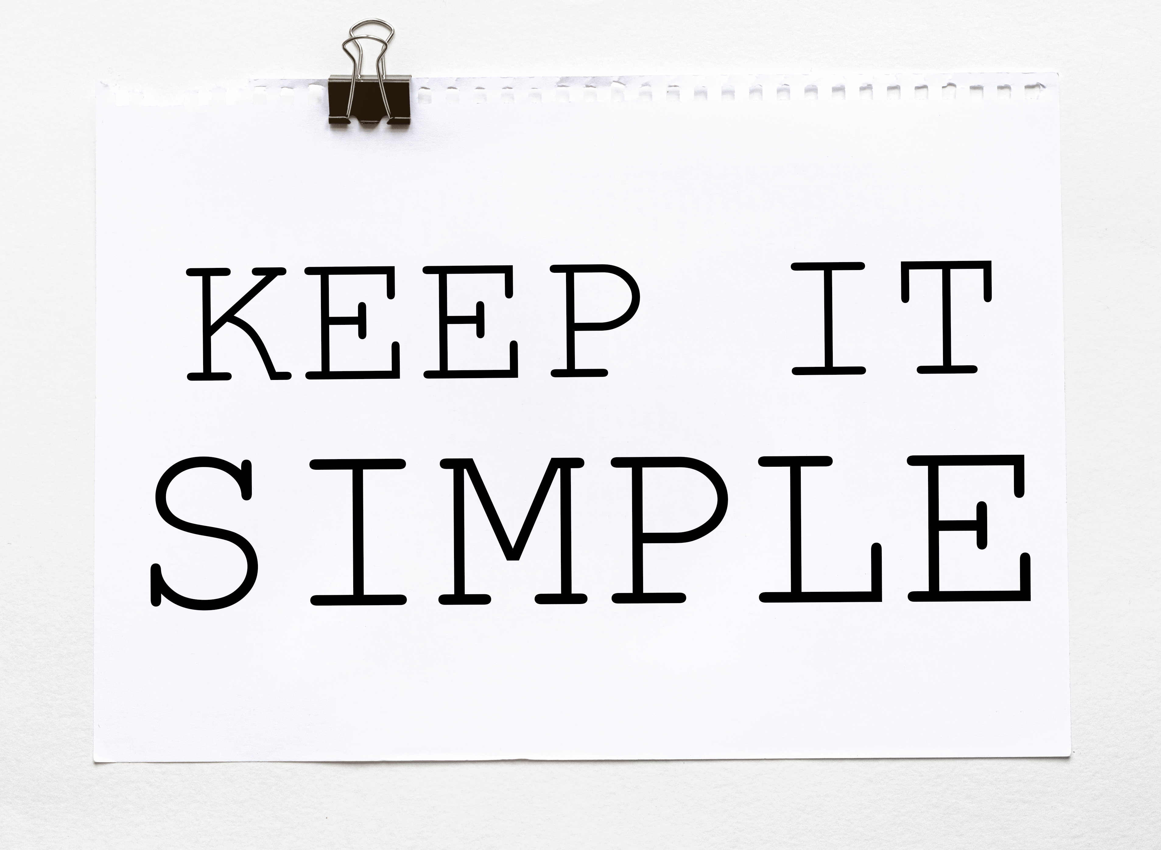 White paper with text Keep It Simple on a white background with stationery 
