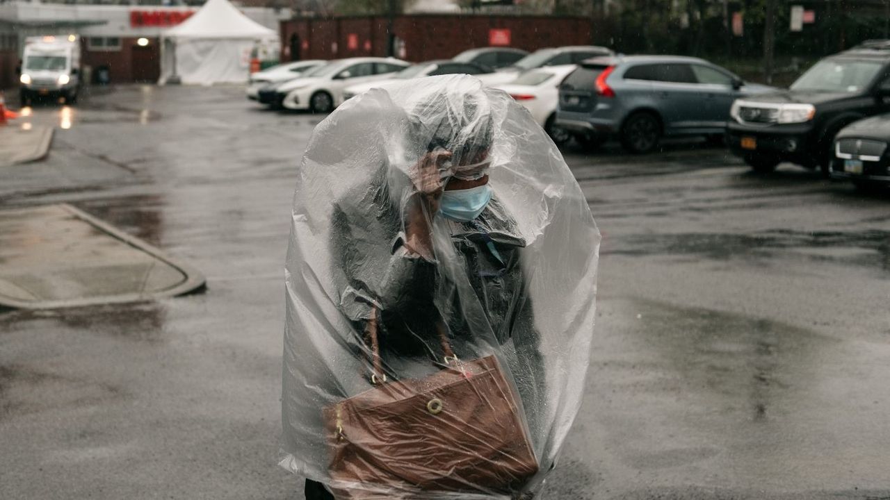 Woman covered in plastic bag wears mask to protect from Covid-19