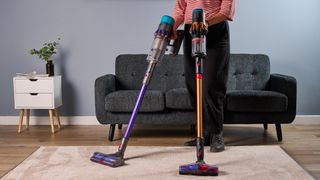 Person holding Dyson V16 and Gen5detect vacuums
