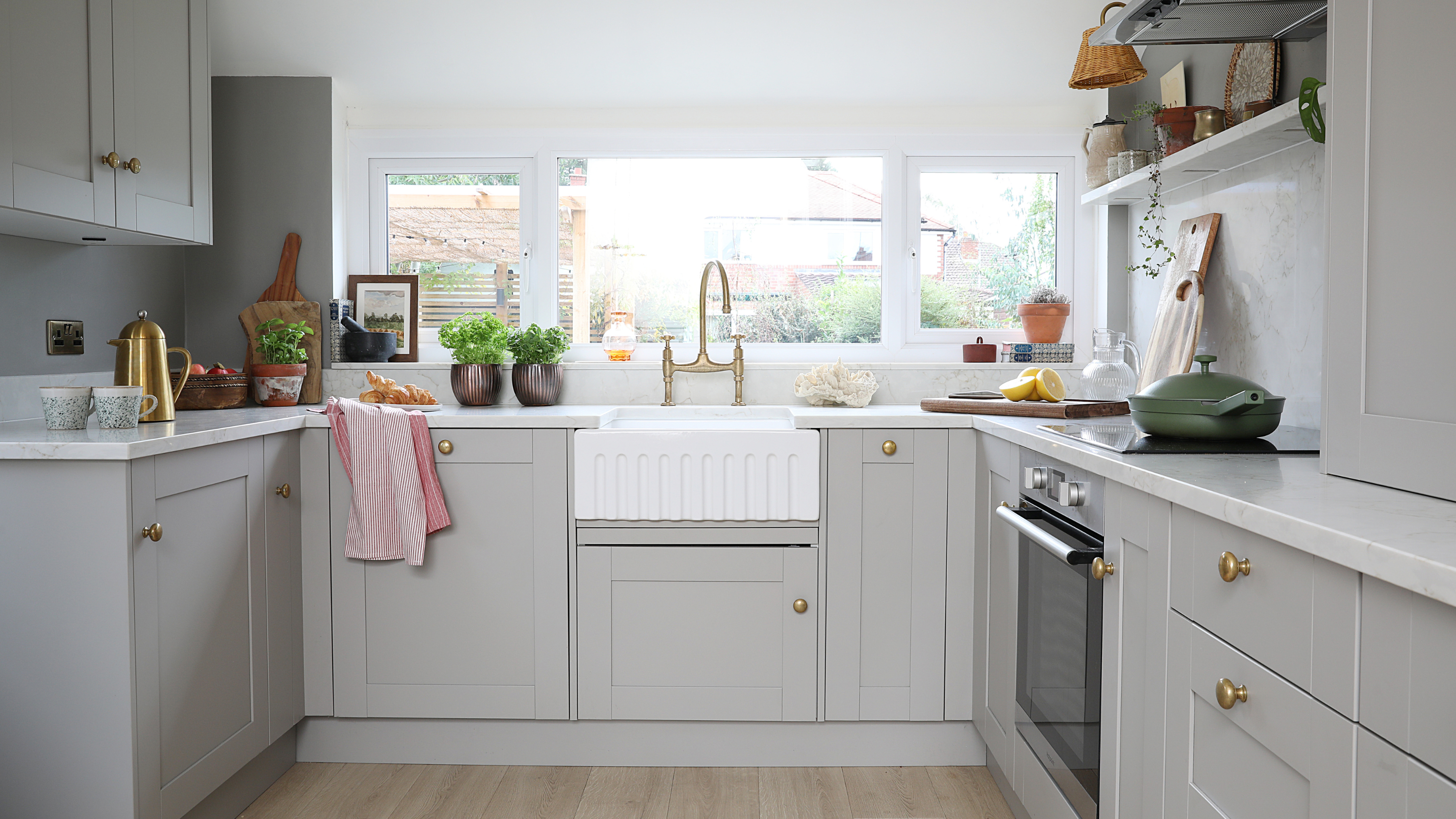 White painted kitchen with grey cabinets and a white worktop