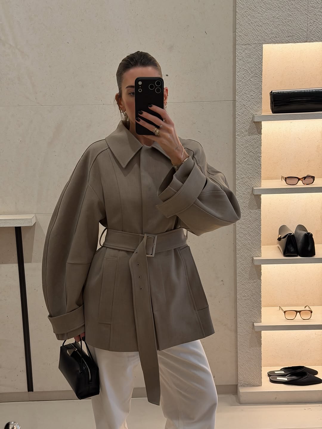 A woman wearing belted jacket, one of the biggest 2026 spring to summer transitional trends.