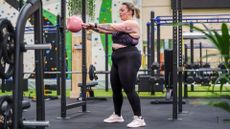 Young larger sized woman working out with kettlebell in gym doing a kettlebell swing