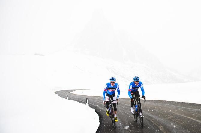 Dan Martin and Alex Rasmussen push through a snow storm on the Passo Giau during a training camp at the end of May.