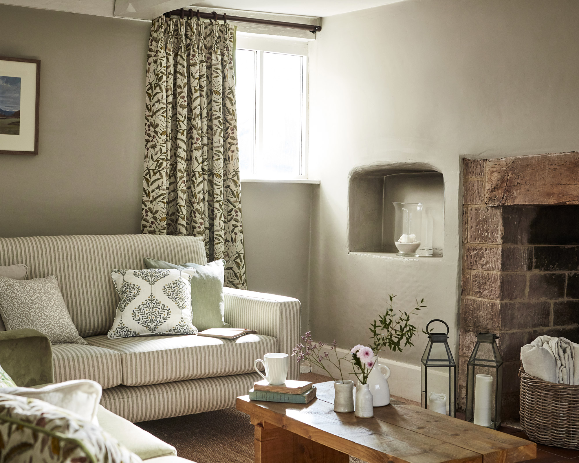 Green Sanderson drapes and striped sofa illustrate cozy living room ideas in a small cottage space.