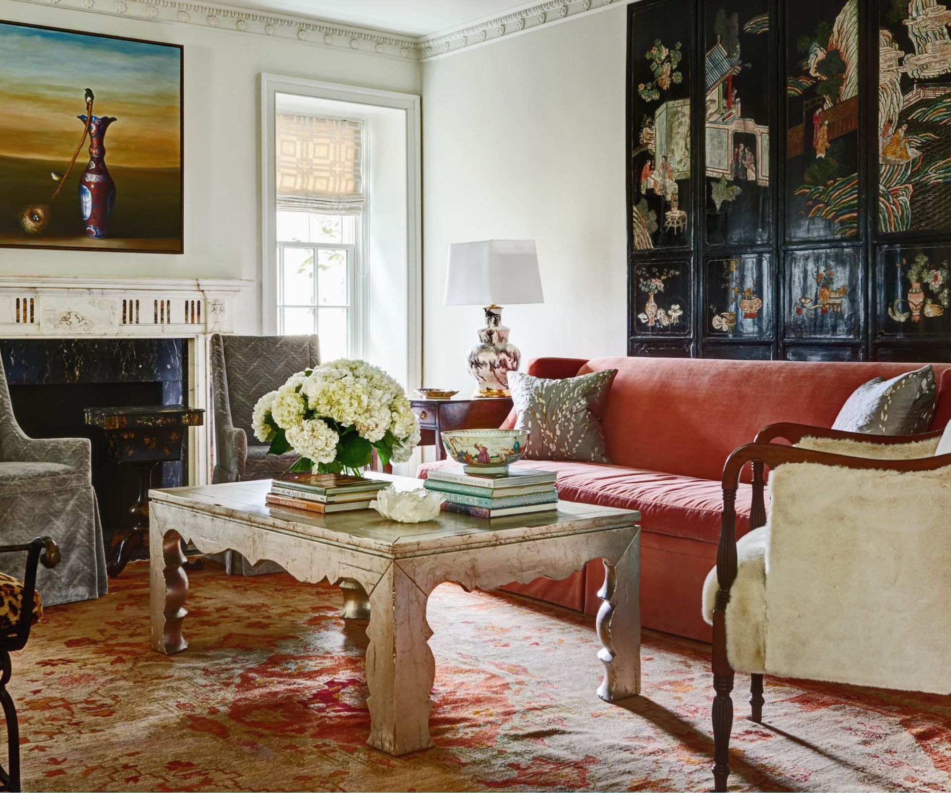 Eclectic living room with velvet sofa, chinese screen and silver table