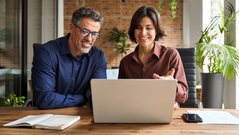 Two happy people - a man and a woman - using a laptop