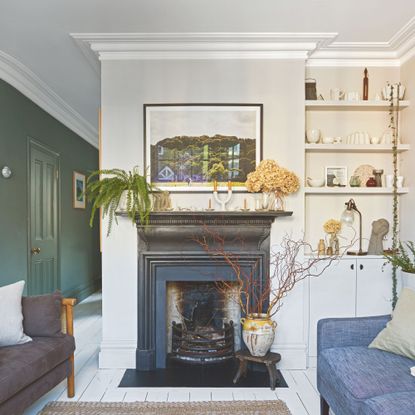 Small living room with a black fireplace on a white painted wall, and sofas either side of it