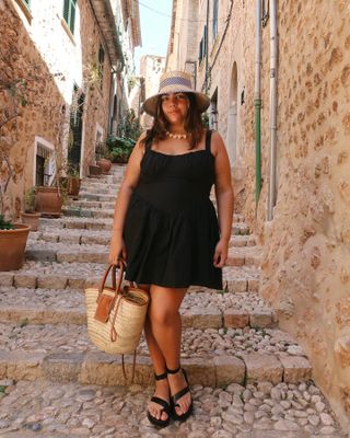 Woman wearing raffia tote bag.