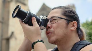 Photographer James Artaius holding a beginner camera from Olympus / OM System