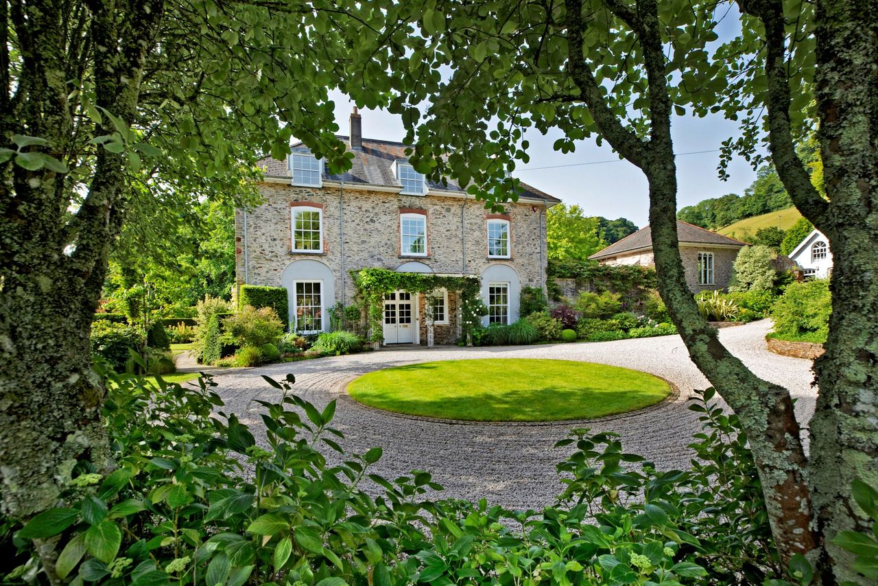 A side view of the home with a large tree in the foreground