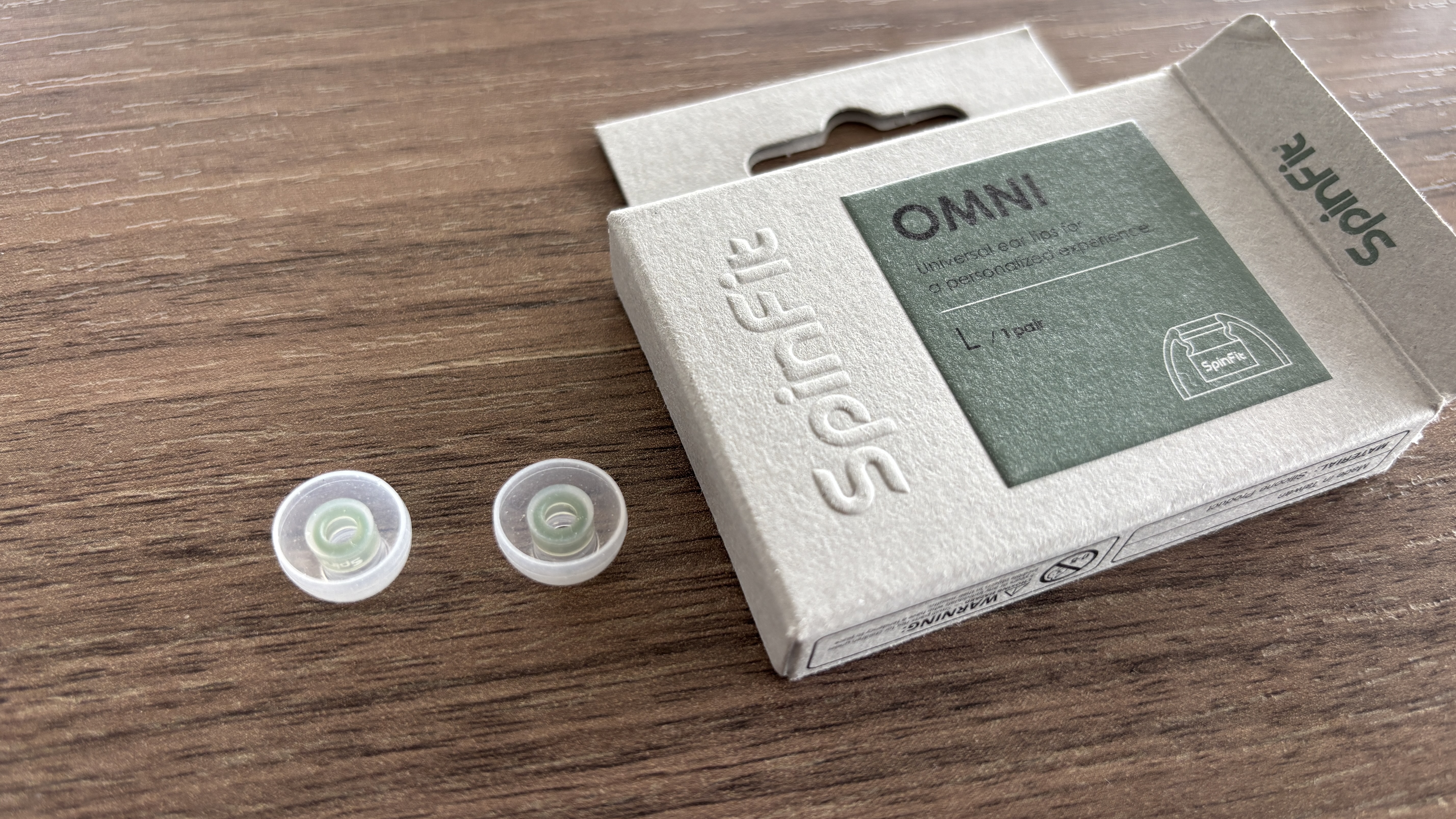 SpinFit Omni eartips on a desk next to their packaging