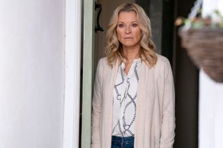 Kathy Beale standing at her front door looking sad in EastEnders