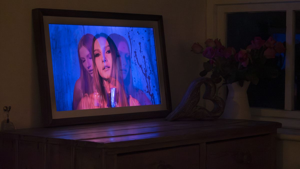 Vieunite Textura digital canvas on a wooden table by a window displaying a vivid portrait, at night