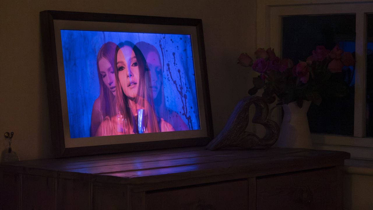 Vieunite Textura digital canvas on a wooden table by a window displaying a vivid portrait, at night