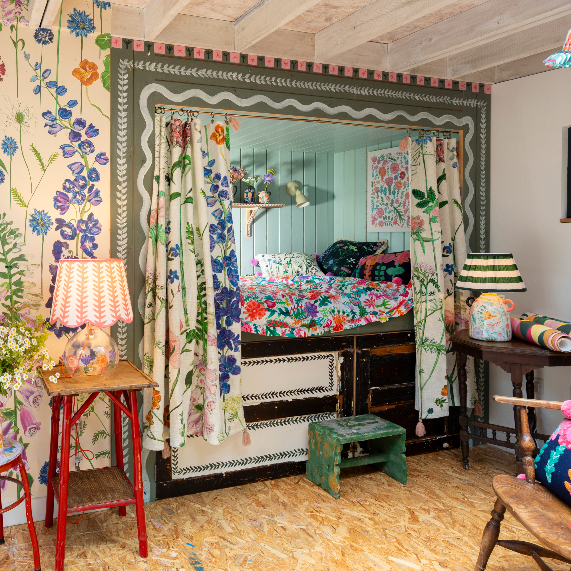 hand-painted walls with a small built-in bed with floral curtains