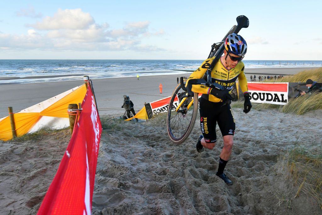 Wout van Aert (Jumbo-Visma) runs up the sand dune