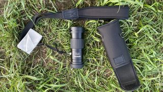 An Opticron Explorer WA ED-R 8x42 monocular on the ground with its accessories.