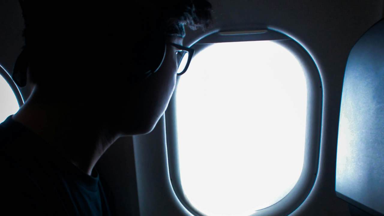 A person in headphones looking out a plane window