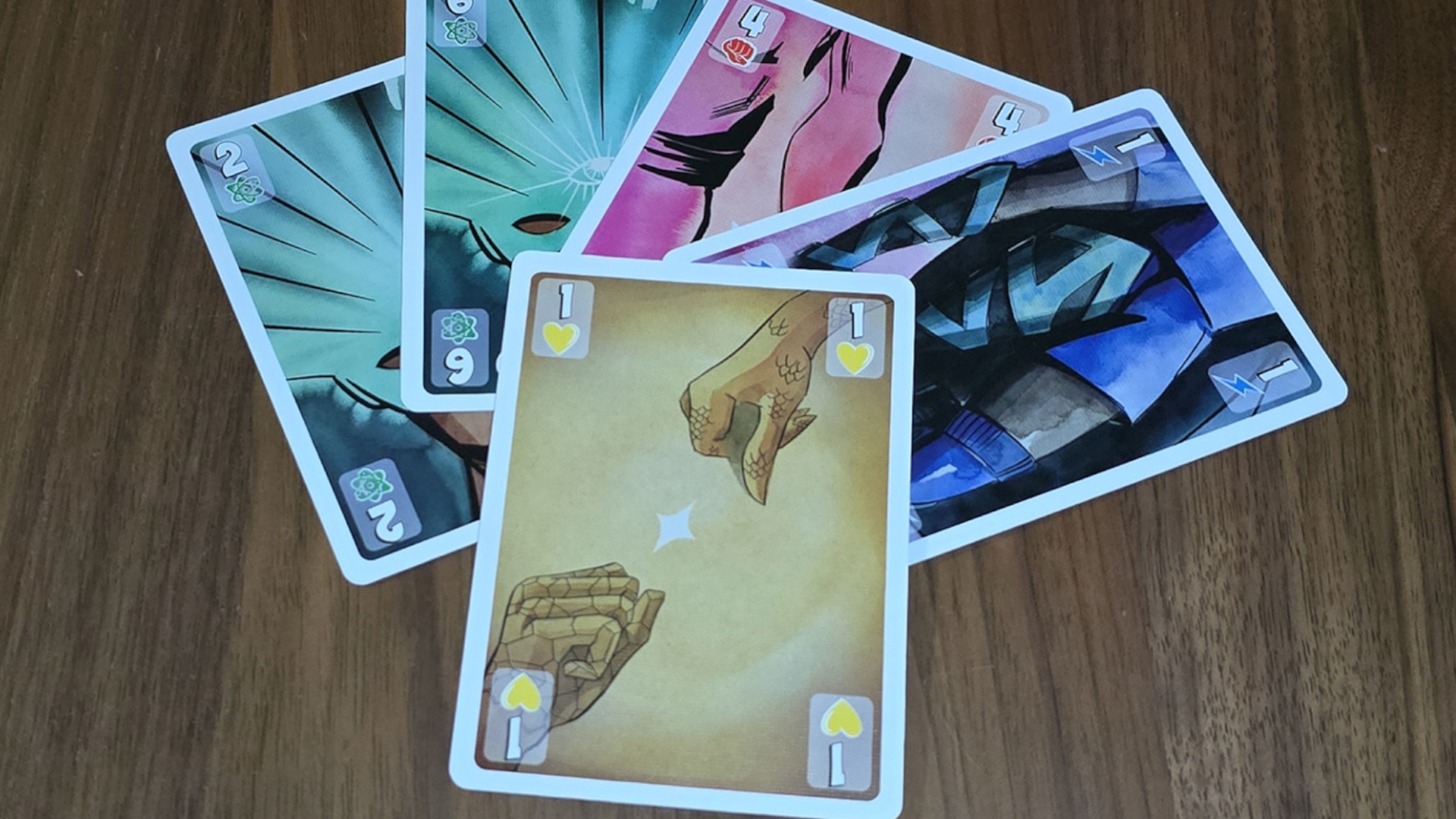 An array of Origin Story cards laid out on a wooden surface