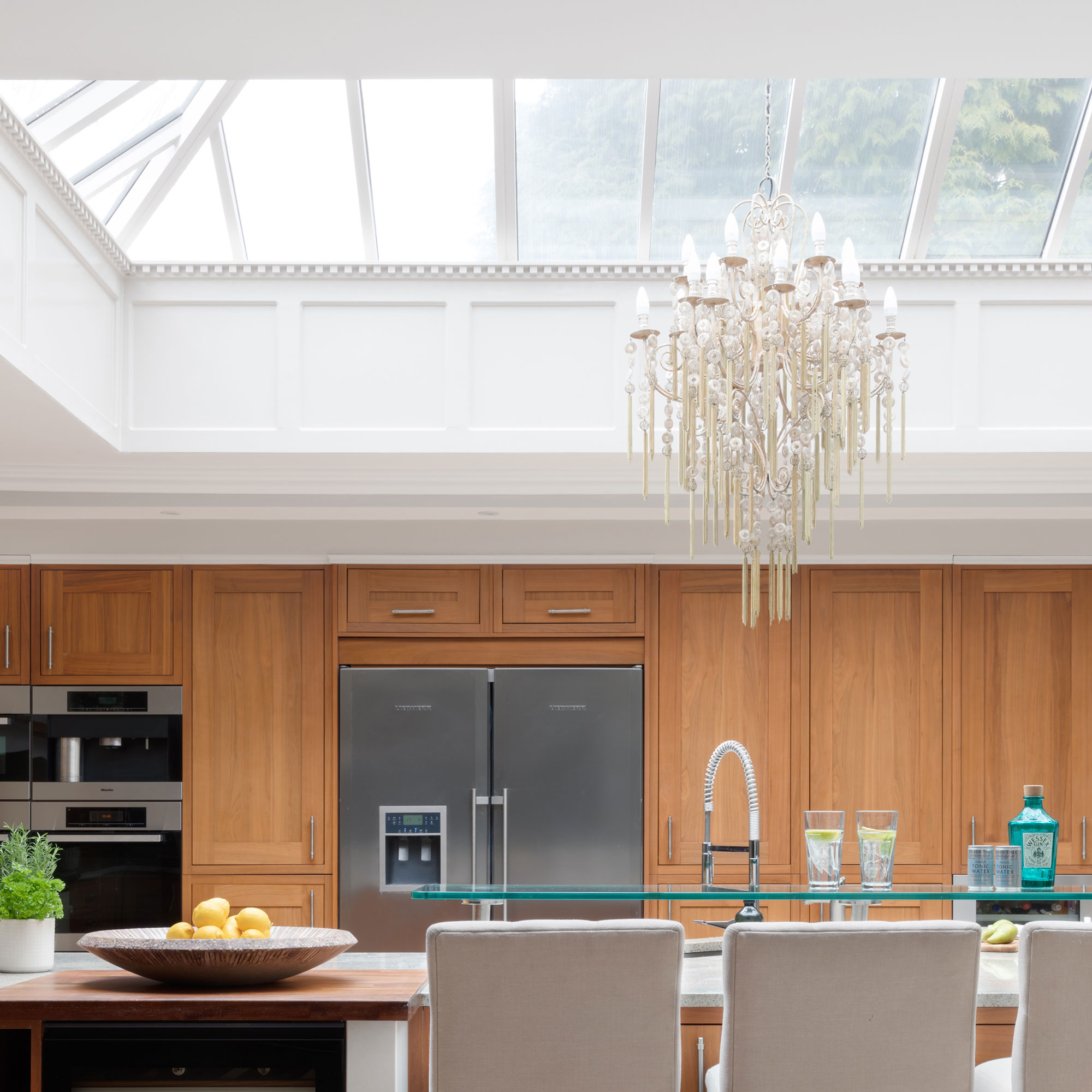 wooden kitchen with large roof lantern over kitchen island and chandelier