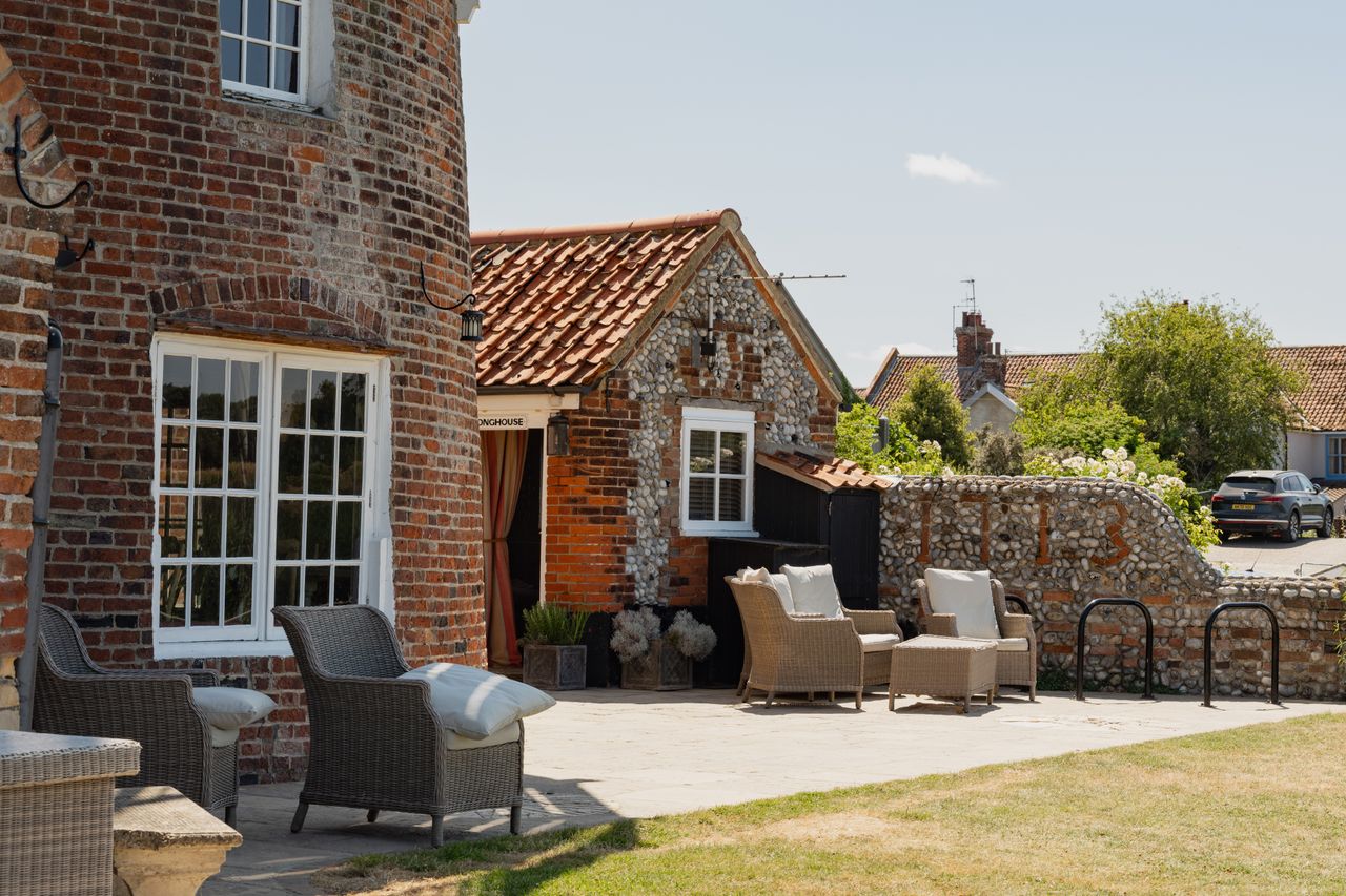 Cley Windmill. The mill is surrounded by reed beds and little rivers, and it is red brick with a white top. Inside, the rooms are luxurious but rustic, with lots of brick and exposed beams.