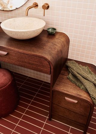 a dark red bathroom with a wood vanity