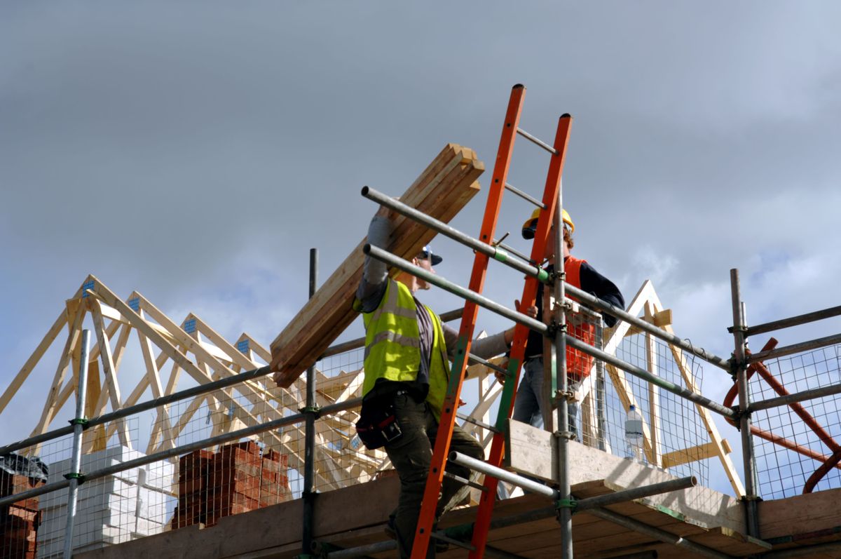 Building Safety Act will affect all builders such as these two on top of this roof of this new home