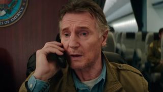 Liam Neeson sits on the phone in a plane in Cold Storage.