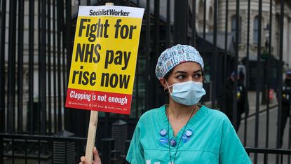 A nurse holds a sign outside downing street