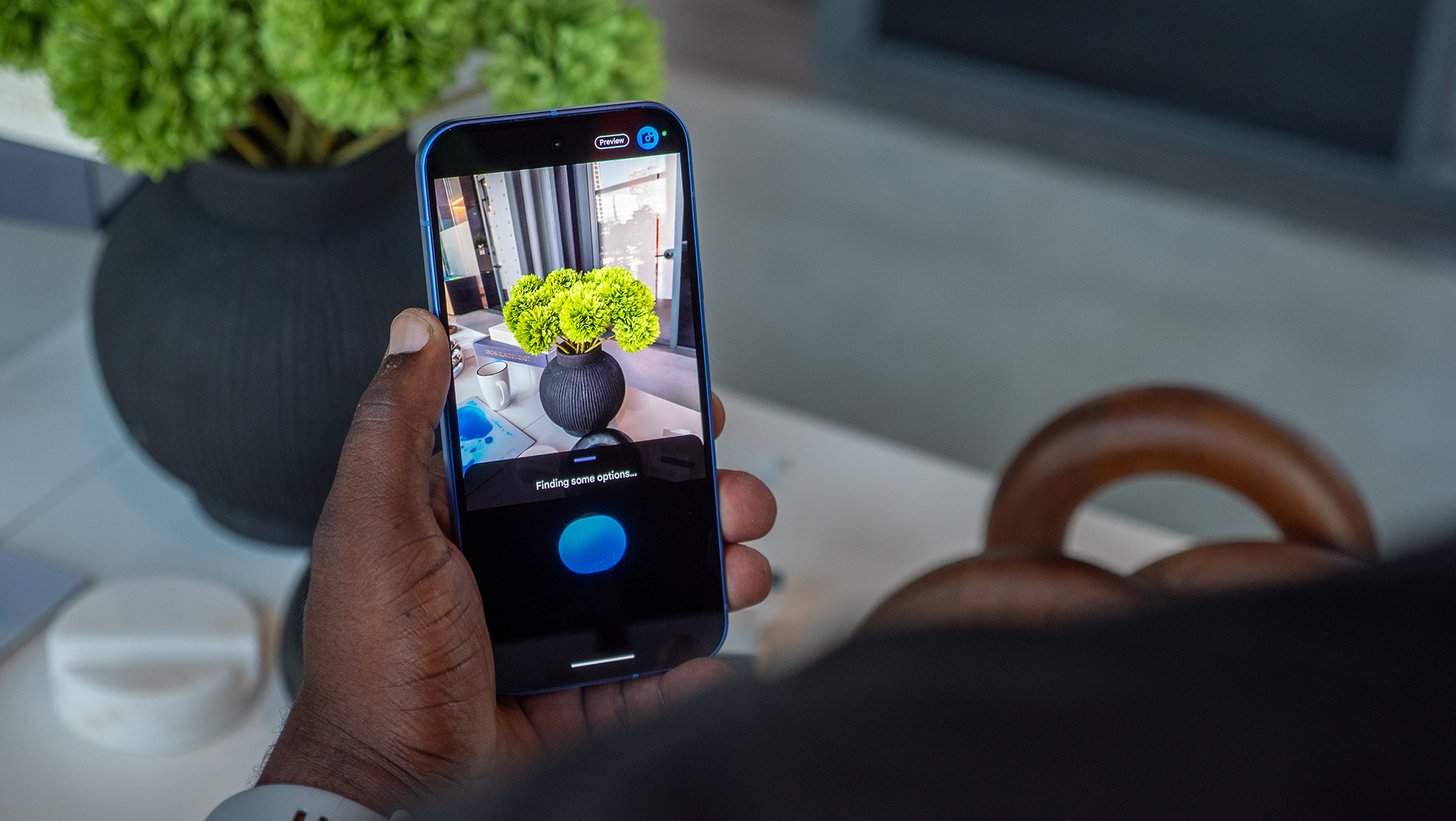 Using Camera Coach on a blue Google Pixel 10 to take a picture of a potted plant