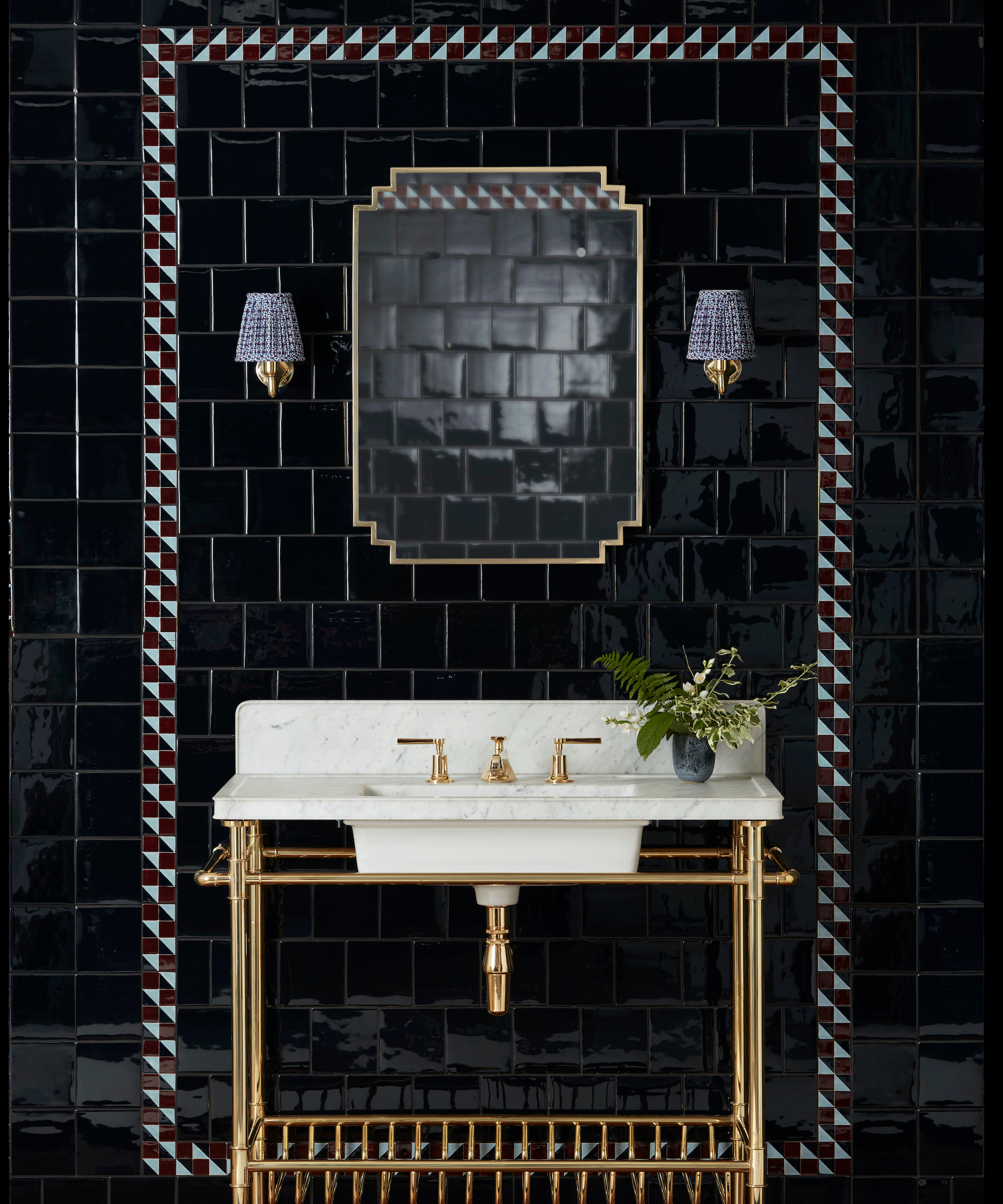 Bathroom sink with black glossy wall tiles and a decorative border