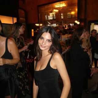 Emily Ratajkowski wears a square neck black dress whilte attending a wedding in new york city.