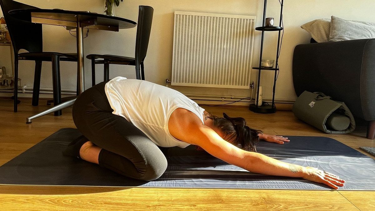 Woman performing child&#039;s pose on the Lululemon Take Form yoga mat side on