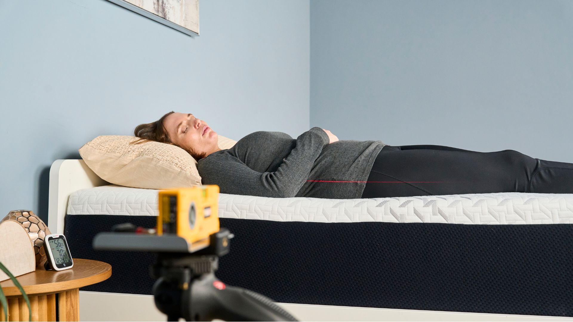 A laser pen measures how well tester Ruth Jones's spine is aligned when back sleeping on the Nectar Premier Memory Foam Mattress.