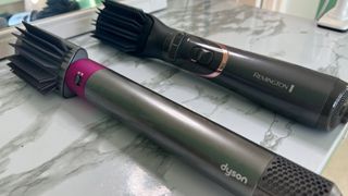 The Remington Curl and Straight Confidence Airstyler AS8606 with the paddle brush attachmenet cvonnected next to the Dyson Airwrap with the same accessory connected