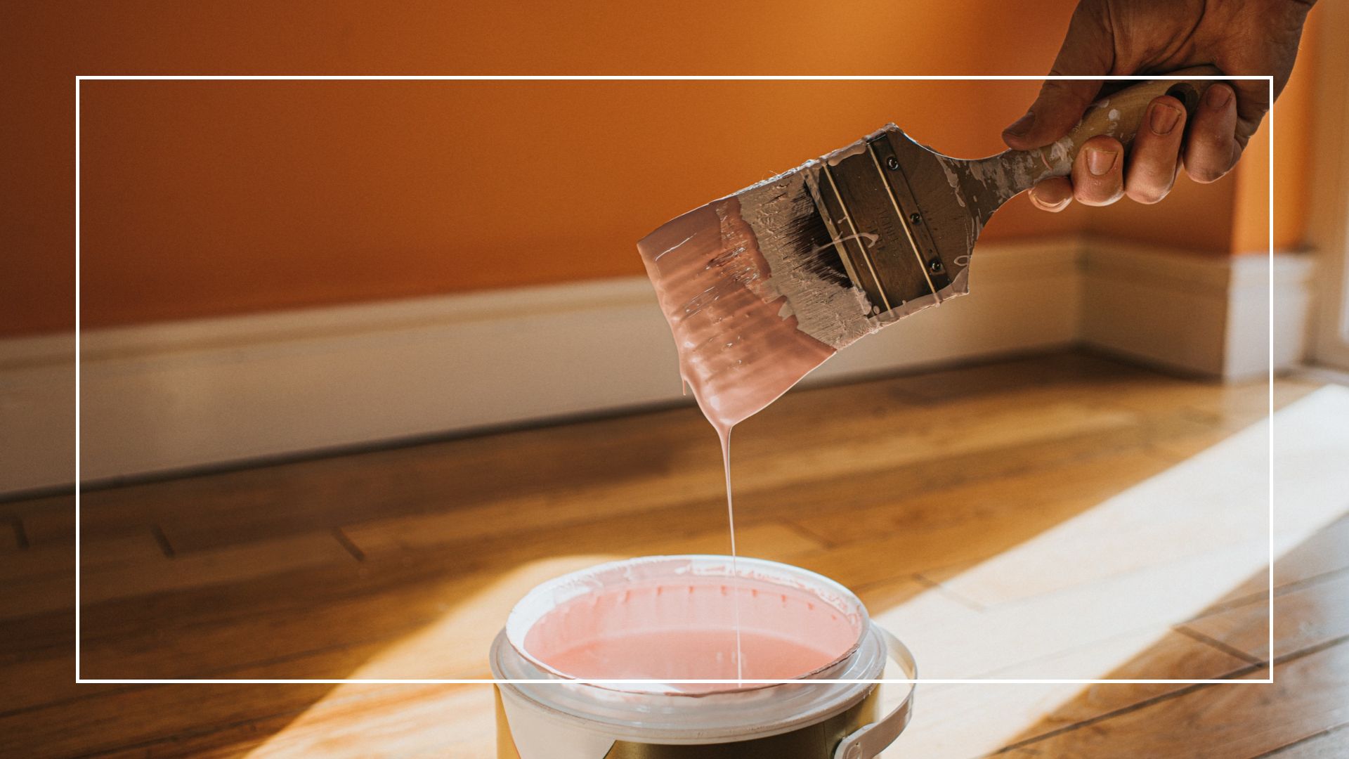 picture of woman holding paint brush with pink paint dripping off 