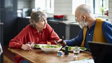 An older couple have an intense conversation over dinner.