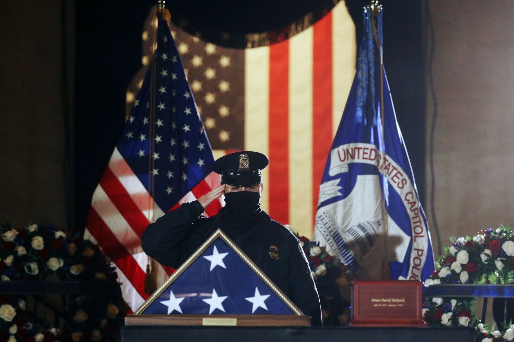 A Capitol Police officer salutes the remains of Officer Brian Sicknick.