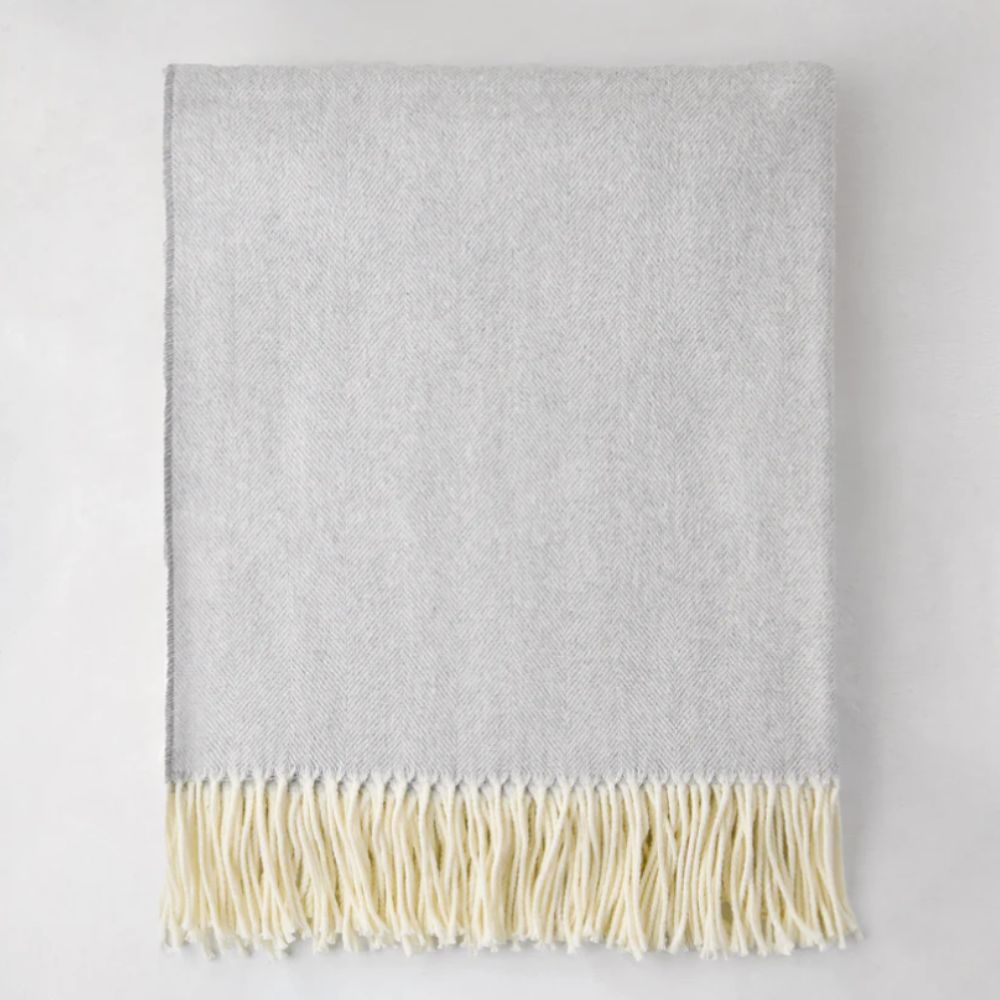 Light gray throw blanket with cream tassles