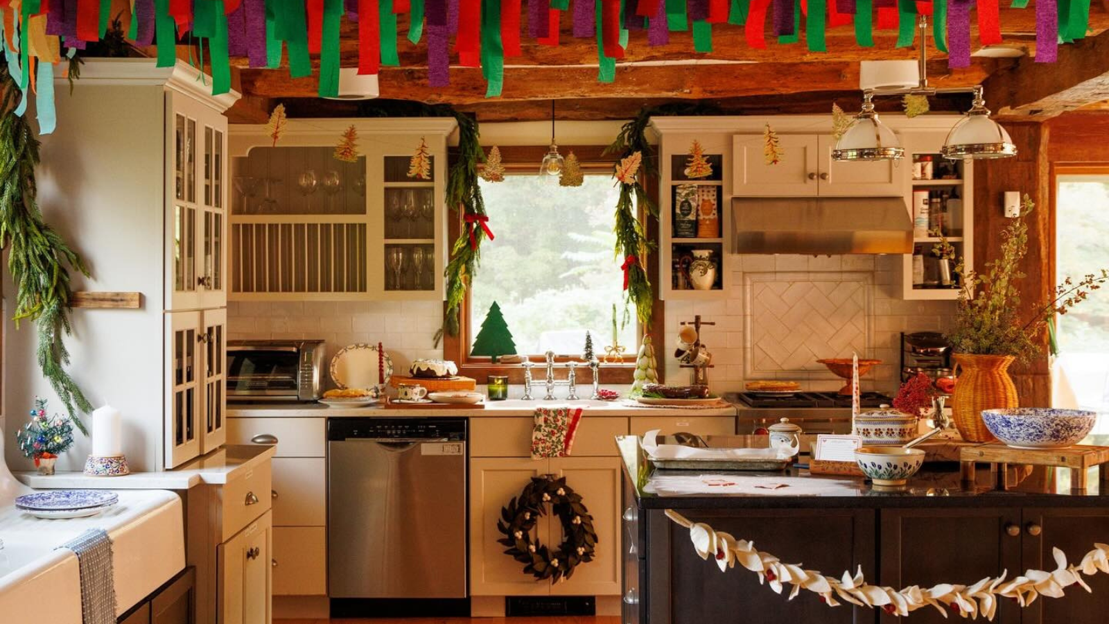 a kitchen decorated for Christmas with various handmade trimmings hanging from the ceiling, the cabinets, and Christmas decor all over the kitchen