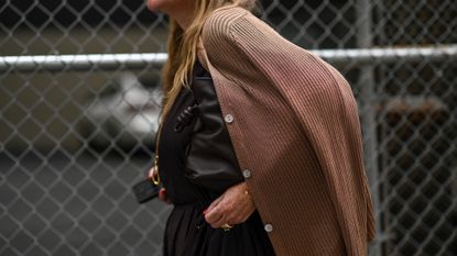 A guest is seen wearing a brown cardigan, brown top, brown skirt and a black bag outside the Tibi show during NYFW S/S 2024 on September 09, 2023 in New York City.