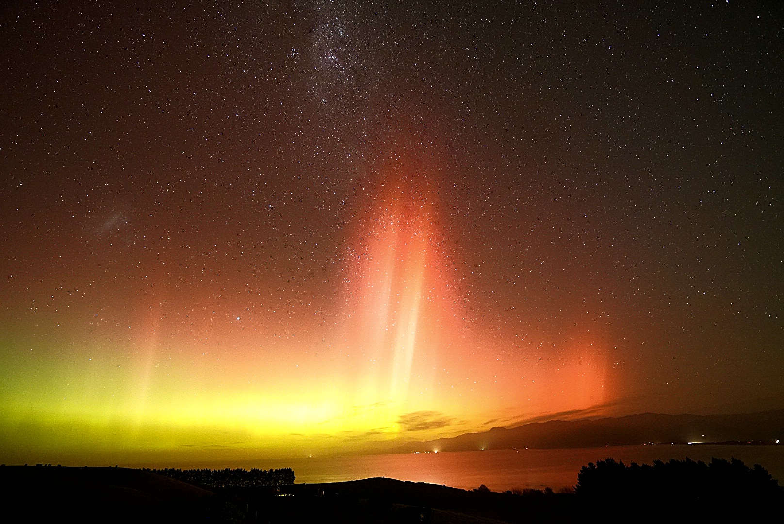 auroras colored yellow and red above kaikoura New Zealand.