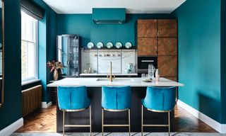Turquoise kitchen color ideas with bright walls and bar stools and white countertops.