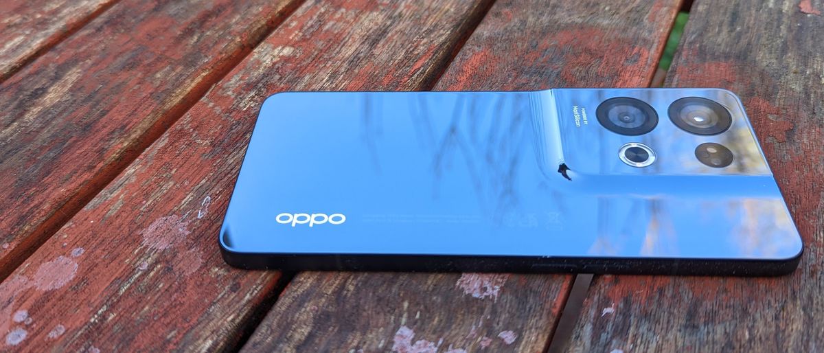 An Oppo Reno 8 Pro smartphone sitting on a rustic table