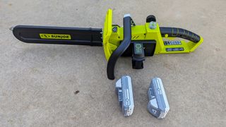 The two 24-volt batteries fit on the side of the chainsaw, while the oil cap is found atop the main body of the machine.