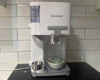 Wide shot of Cuisinart Soft Serve Ice Cream Maker on black induction hob in white tiled kitchen